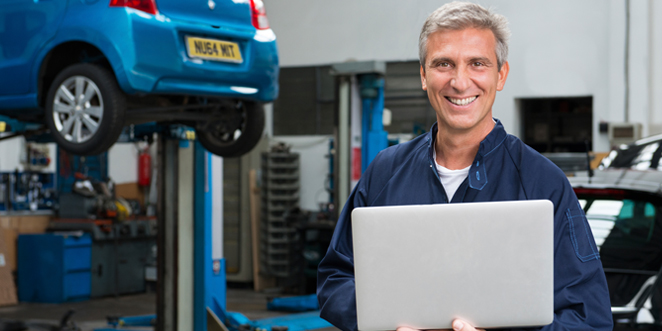 Mechanic using MAM Autowork Online in a garage workshop